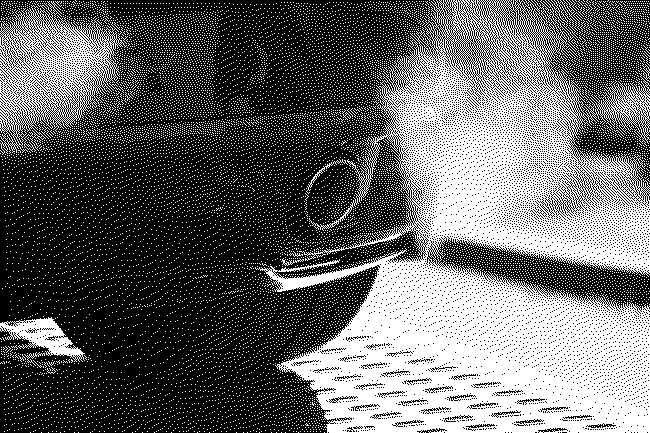 Dithered black-and-white image of a car exhaust