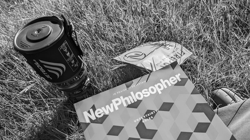 Jetboil stove, New Philosopher magazine and Firepot food pouch on grass.