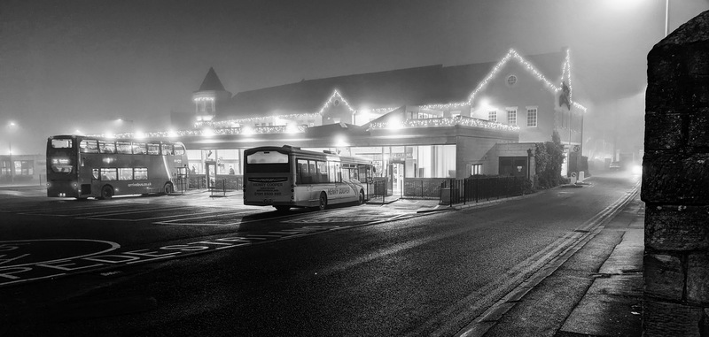 Morpeth bus station with Christmas lights. Black and white photo. Fog.