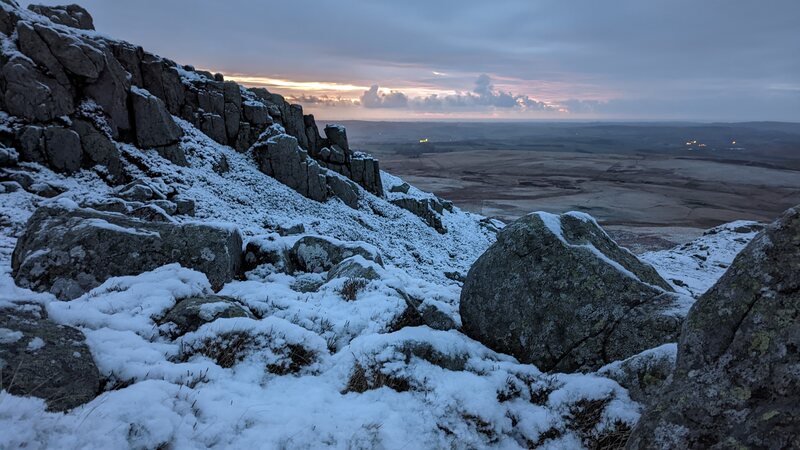 Dawn over the Cheviots with snow on rocks in the foreground