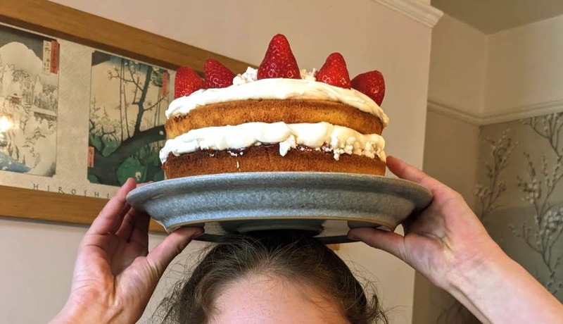Eton Mess cake on a plate being held aloft over a head