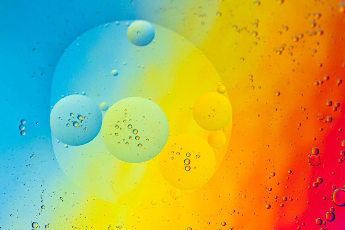 A close up of water droplets on a rainbow colored surface
